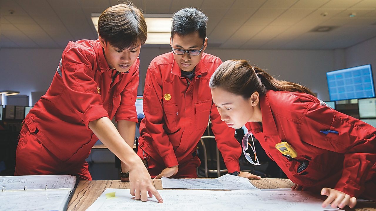 Three employees reviewing plans