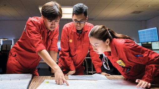 Three employees reviewing plans