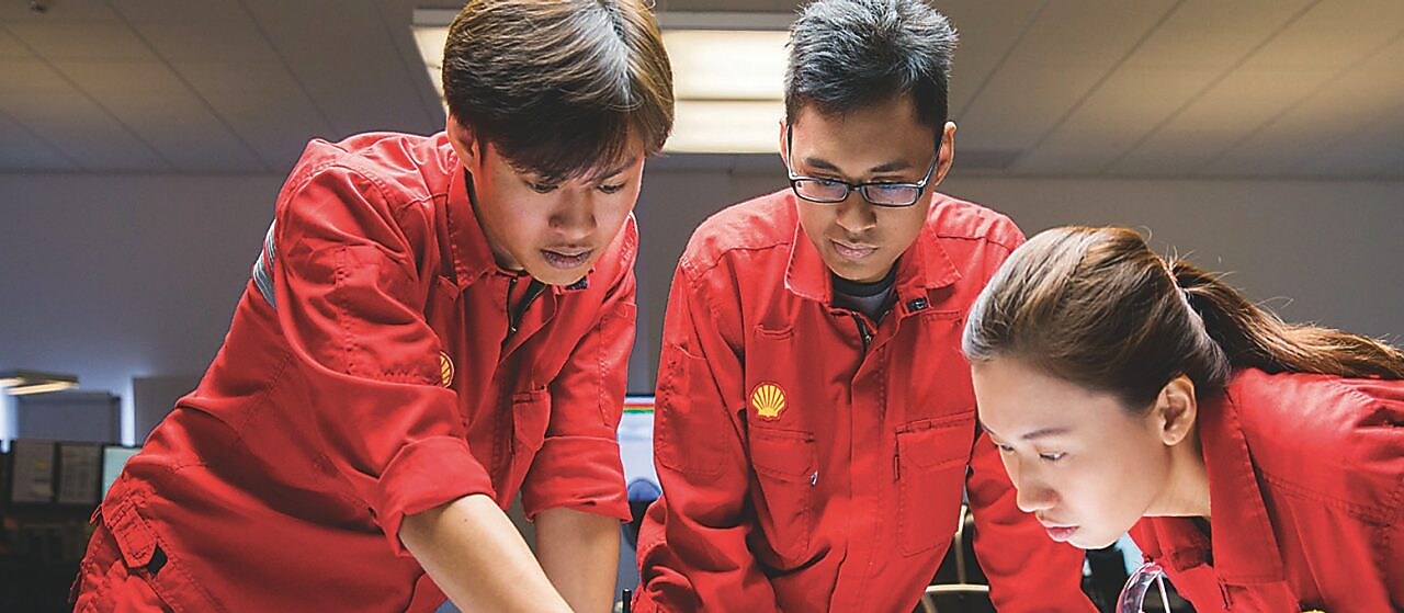 Three employees reviewing plans