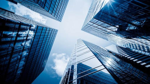 Looking up at the sky between reflective buildings