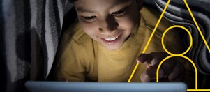 Photo of young boy looking at a tablet with an outline of the Powering lives graph