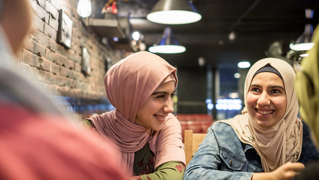 Two women sitting at a table smiling