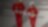 Male and female worker in red overalls and white helmets and hearing protection walking