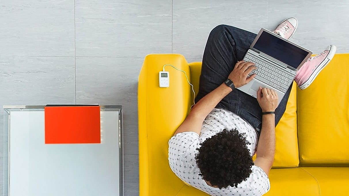 A man sitting on a sofa with his laptop