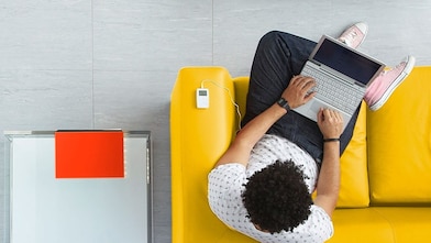 A man sitting on a sofa with his laptop