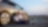 Couple sitting next to a car at sunset.