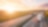 Trucks driving on a highway at sunset.