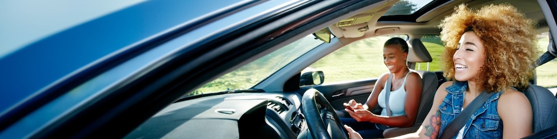 Two women seated in the front seat of a car.