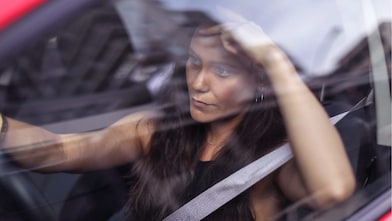Woman driving red car with seat belt on