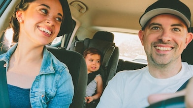 Family of three: woman, men and baby in car set inside a car