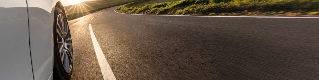 White car moving along a highway.