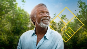 Hombre sonriente con barba delante de unos árboles con un resumen del gráfico de generación de valor para el accionista