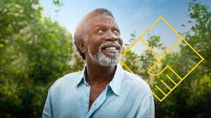 Hombre sonriente con barba delante de unos árboles con un resumen del gráfico de generación de valor para el accionista