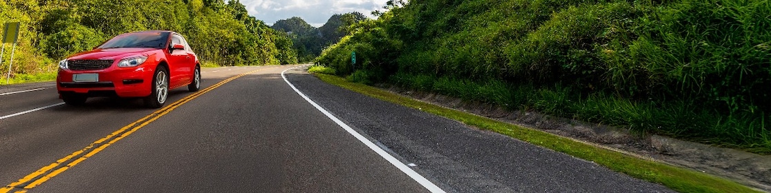 Auto rojo en movimiento en una carretera.