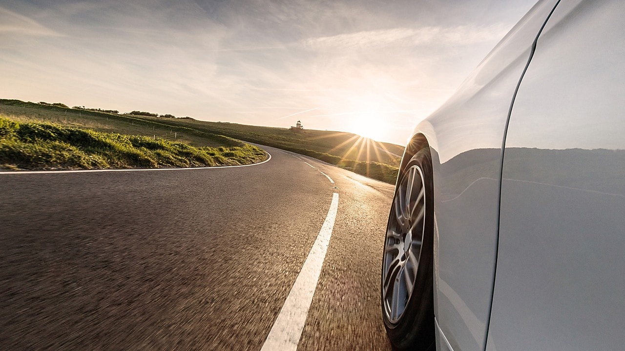 Auto blanco en movimiento en una carretera.