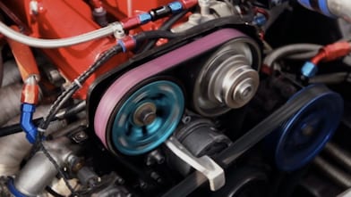 Motor de auto con correas visibles en primer plano.