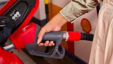 Mujer echando gasolina a su auto con pistero
